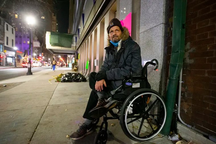 Dave Daniels, Sr., a resident of the city's COVID-19 hotel for vulnerable people in Center City, sits outside the hotel — a Holiday Inn — earlier this month. The city is closing the hotels down as federal funding runs out.