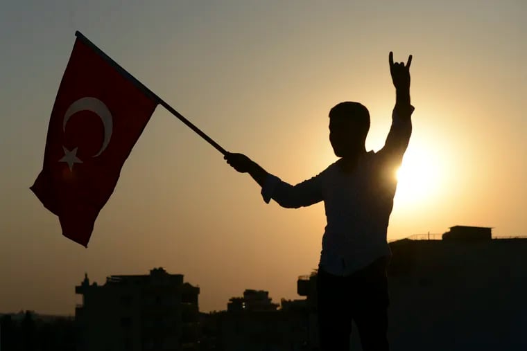 A Turkish youth celebrates with a national flag in the border town of Akcakale, in Sanliurfa province, on Sunday.