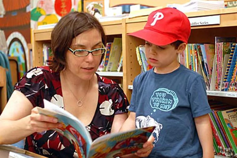 Alexandra Brock reads to her son Yannick, 3 at the Independence Branch of the Free Library. (Tom Gralish / Staff Photographer)