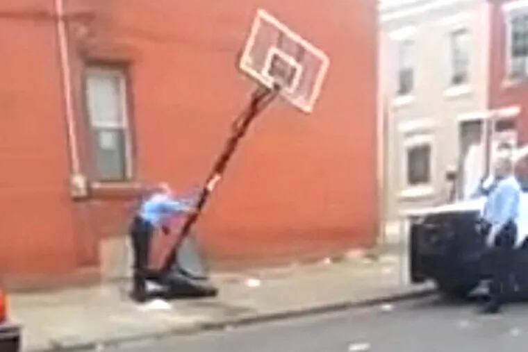 Officer Nace pushing over a basketball net.  Video screenshot http://www.youtube.com/v/9JoBFc1K-m8?hl=en_US&amp;version=3