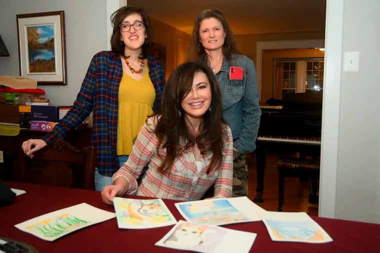 Authors Lucy Noland (center) and Susan Russell (right), joined by Illustrator Kaity Lacy go over the pages for their upcoming book, in West Mount Airy, Philadelphia, on Feb. 18.