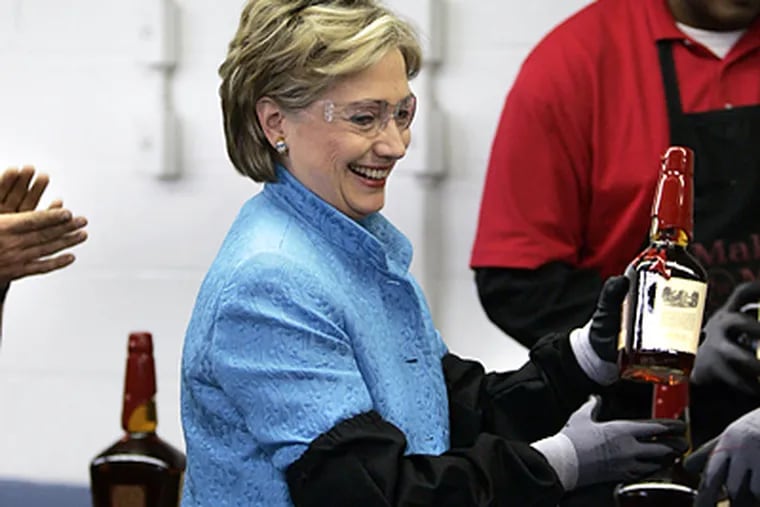 Sen. Hillary Rodham Clinton holds a bottle she dipped into red wax at the Maker&#0039;s Mark Distillery in Loretto, Ky. She visited there yesterday in advance of Kentucky&#0039;s primary on Tuesday. (Elise Amendola/AP)