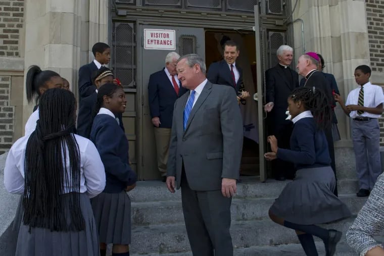 Mayor Kenney speaks with a student after the ribbon-cutting for St. Malachy School in North Philadelphia last year.