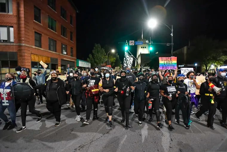 Demonstrators march along a street in Rochester, N.Y., Friday, Sept. 4, 2020, during a protest over the death of Daniel Prude. Prude apparently stopped breathing as police in Rochester were restraining him in March 2020 and died when he was taken off life support a week later.