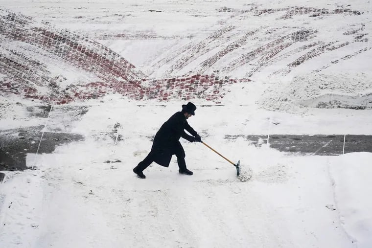 A Saint Paul Hotel doorman clears snow during a mid-April snowfall in Minneapolis. It was a cold, snowy month across the nation.