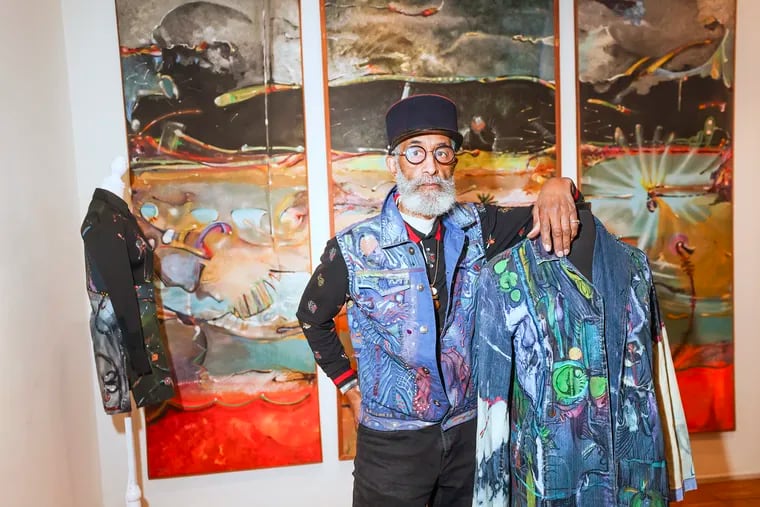 Artist Richard J. Watson poses for a portrait next to pieces from his "Beyond Imagination: Wear-ever You Are" exhibit at the Ultra Silk Gallery in Philadelphia on Wednesday, Dec. 6, 2023.