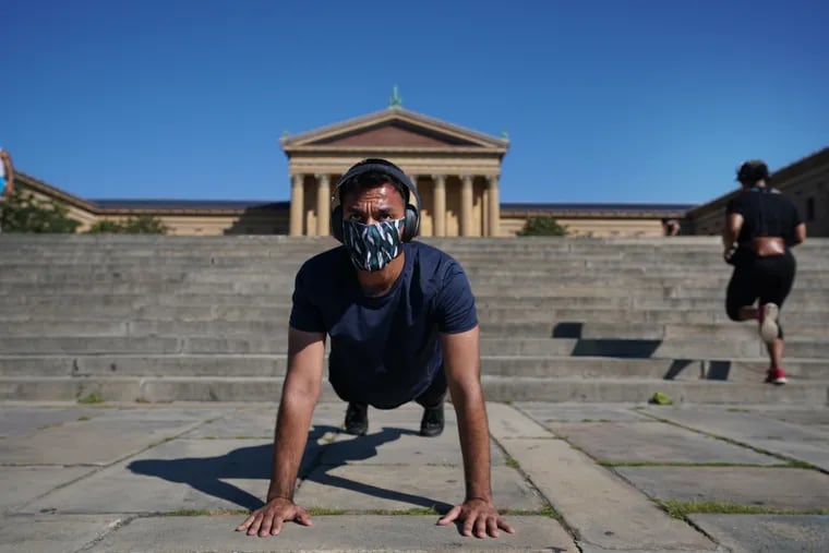 Puneet Sihag does push-ups on the front steps of the Philadelphia Art Museum, while wearing a mask, in Philadelphia, July 2, 2020.