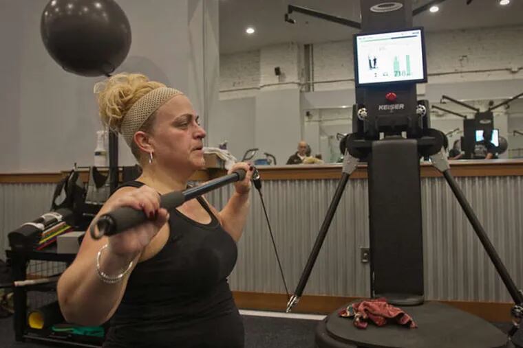 Lisa Stanton, a secretary in the Jefferson department of otolaryngology, works out with the EXOS stability lift bar at the Myrna Brind Center of Integrative Medicine on Chestnut Street.