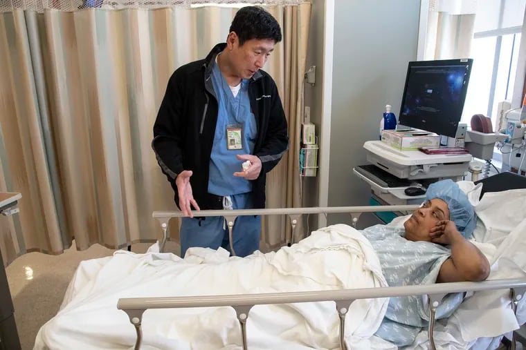 Eric Choi, chief of vascular and endovascular surgery at the Lewis Katz School of Medicine at Temple University and director of the Temple Limb Salvage Center, talks to Carmen Suero minutes before he would attempt to open a blocked blood vessel in her leg at Temple University Hospital. She was at risk of an amputation.