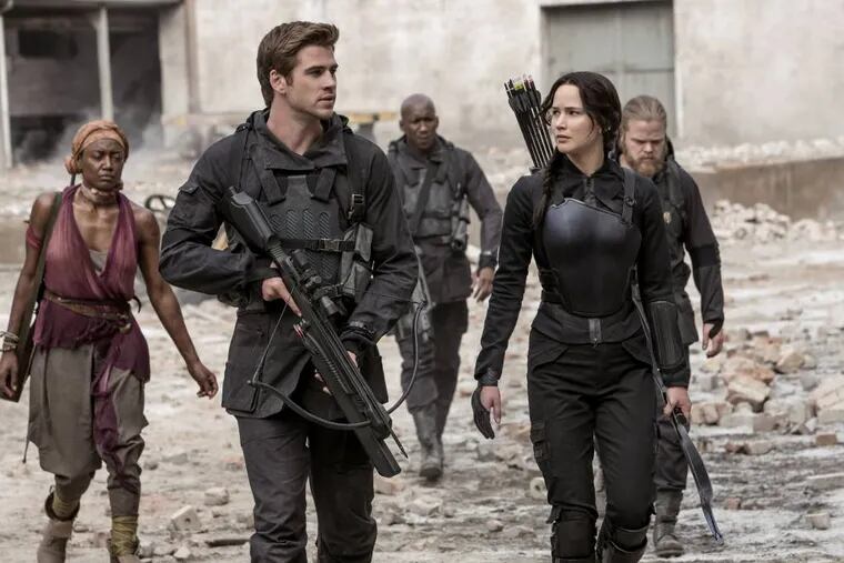 In this image released by Lionsgate, Jennifer Lawrence portrays Katniss Everdeen, right, and Liam Hemsworth portrays Gale Hawthorne in a scene from "The Hunger Games: Mockingjay Part 1." (AP Photo/Lionsgate, Murray Close)