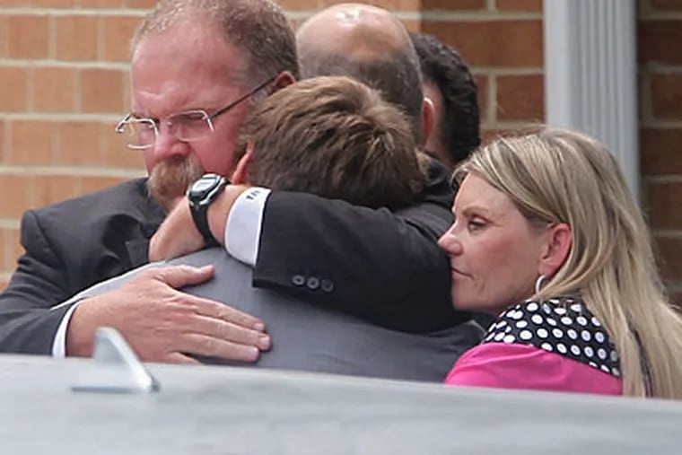 Andy Reid hugs his son Britt and wife Tammy following the funeral service for Garrett Reid on Tuesday. (Michael Bryant/Staff Photographer)