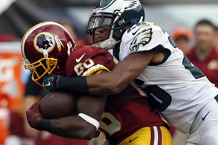 Eagles cornerback Cary Williams tries to bring down Redskins wide receiver Pierre Garcon. (Yong Kim/Staff Photographer)