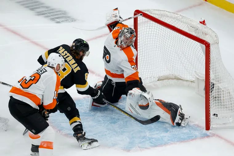 Boston Bruins right wing David Pastrnak taps home the Bruins' opening goal past Flyers goalie Carter Hart on Monday.