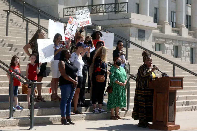 On May 19, 2021, Betty Sawyer joins educators and community activists in protesting Utah lawmakers' plans to pass resolutions encouraging a ban of critical race theory concepts outside of the Capitol in Salt Lake City as both supporters and counterprotesters stand behind her.