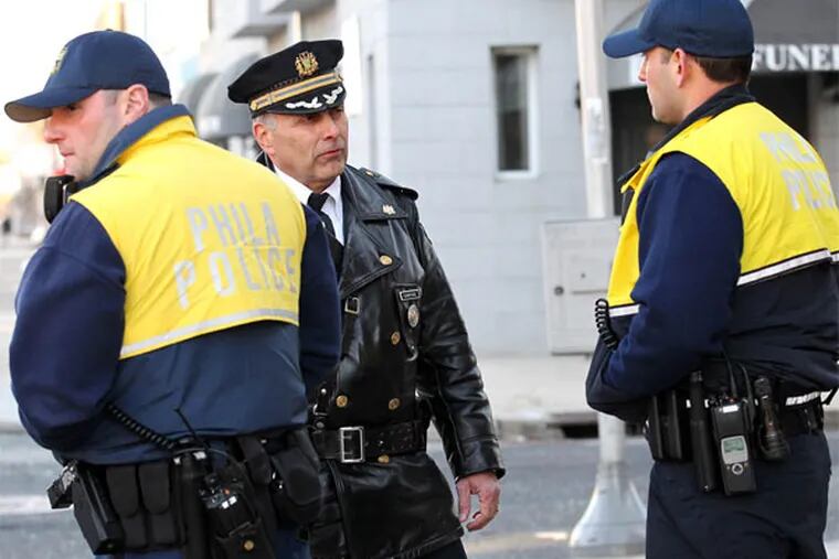 Capt. Lou Campione (center), commander of the 1st District, talks with bike officer Andrew Runowski while another, Jayson Troccoli, stands nearby on the 2000 block of Snyder Avenue in South Philly. (Yong Kim / Staff Photographer)
