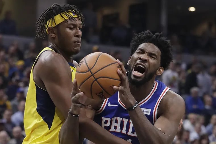Joel Embiid is fouled by Myles Turner (left) during the first half.