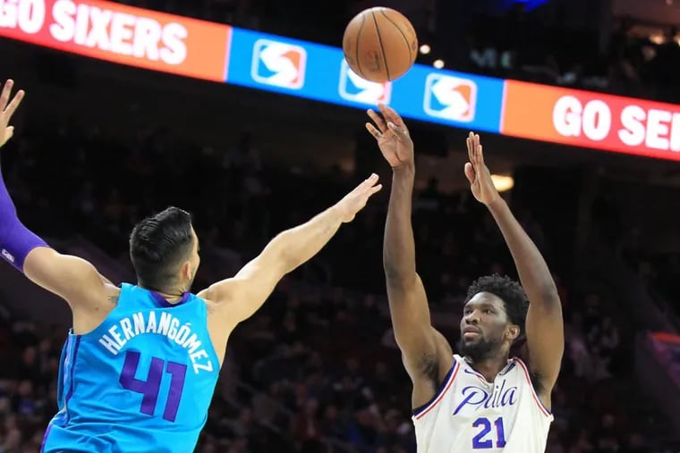 Joel Embiid, right, of the Sixers shoots a 3-pointer over Willy Hernangomez of the Hornets during the 1st half at the Wells Fargo Center on March 2, 2018. CHARLES FOX / Staff Photographer