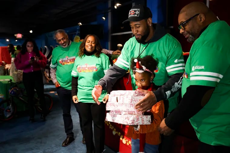 Eagles’ linebacker Haason Reddick hands over a stack of gifts to Zoe Smith, 7.