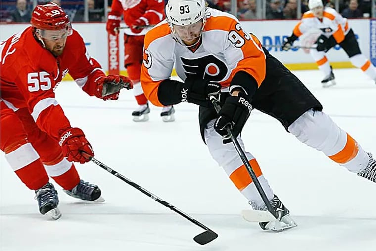 Flyers right wing Jakub Voracek and Red Wings defenseman Niklas Kronwall battle for the puck in the first period. (Paul Sancya/AP)