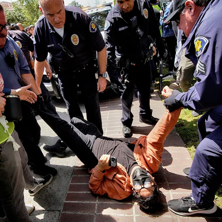 A University of Southern California protester is detained by USC Department of Public Safety officers during a pro-Palestinian occupation at the campus' Alumni Park on Wednesday, April 24, 2024 in Los Angeles.