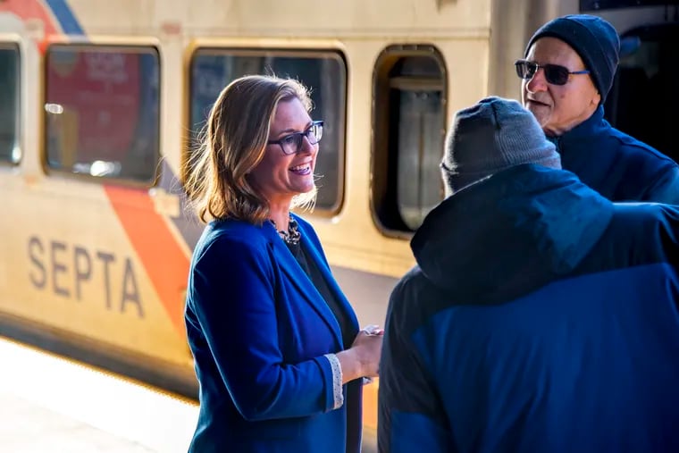 City Council candidate Eryn Santamoor talks with voters at SEPTA's Chestnut Hill West station.