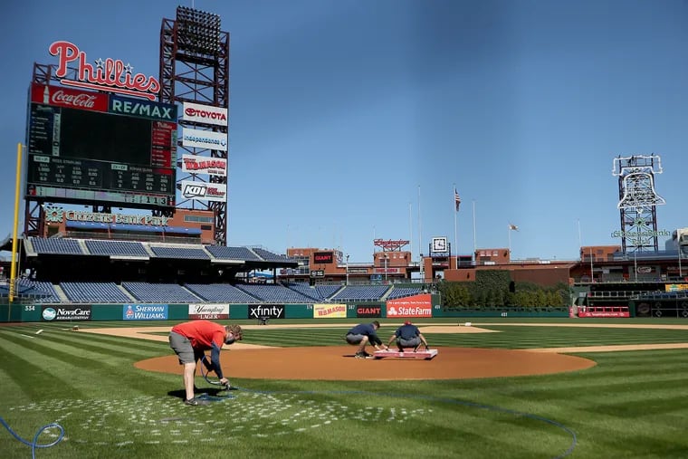 Jeremy Wilt, manager of field operations, painted the “Opening Day” logo on the field at Citizens Bank Park on Tuesday. The Phillies will open the season Thursday against the Atlanta Braves.