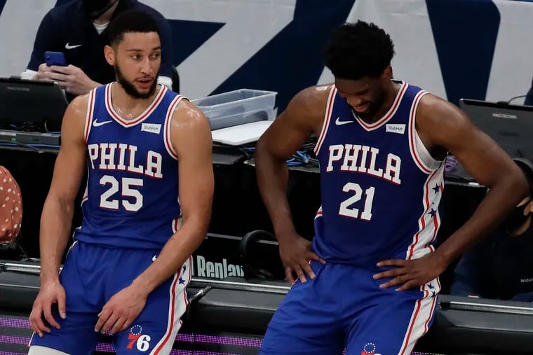 Sixers guard Ben Simmons and center Joel Embiid during a break against Washington Wizards in Game 4. Embiid grimaces in pain.