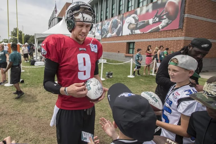 Eagles quarterback Nick Foles signs autographs for Pop Warner football players Monday after practice.