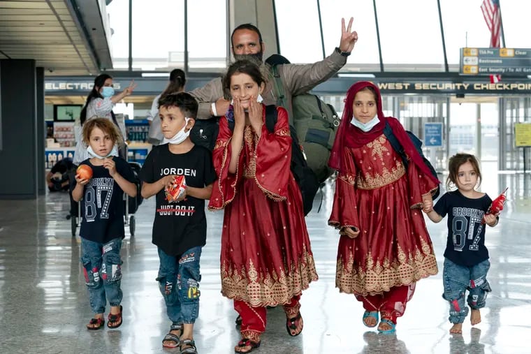Families evacuated from Kabul, Afghanistan, walked through the terminal before boarding a bus after they arrived at Washington Dulles International Airport, in Chantilly, Va., on Aug. 27, 2021.