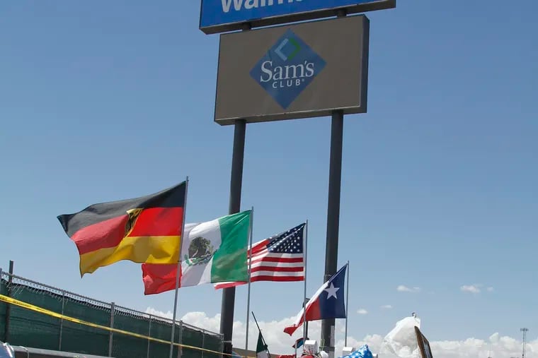 In this Aug. 12 photo, mourners visit the makeshift memorial near the Walmart where 22 people were killed in a shooting that police are investigating as a terrorist attack targeting Latinos. A Walmart spokesman said the store will reopen eventually and build a permanent memorial. The flags show the nationalities of those killed in the attack, including a German man who lived in nearby Ciudad Juarez, Mexico. (AP Photo/Cedar Attanasio)