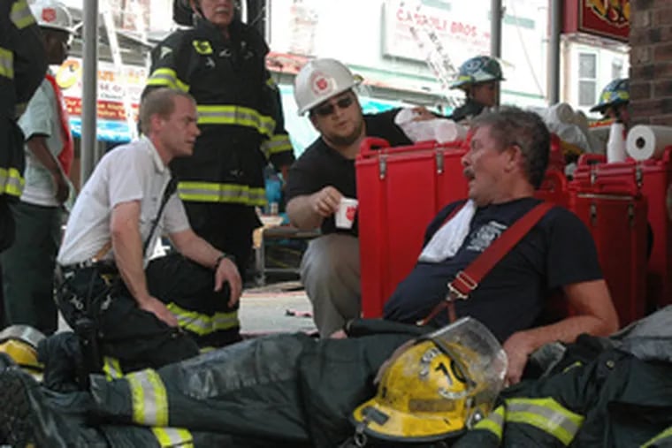 Firefighter Michael Welloch (right), from Engine Company 10, lies exhausted after helping to battle the fire.