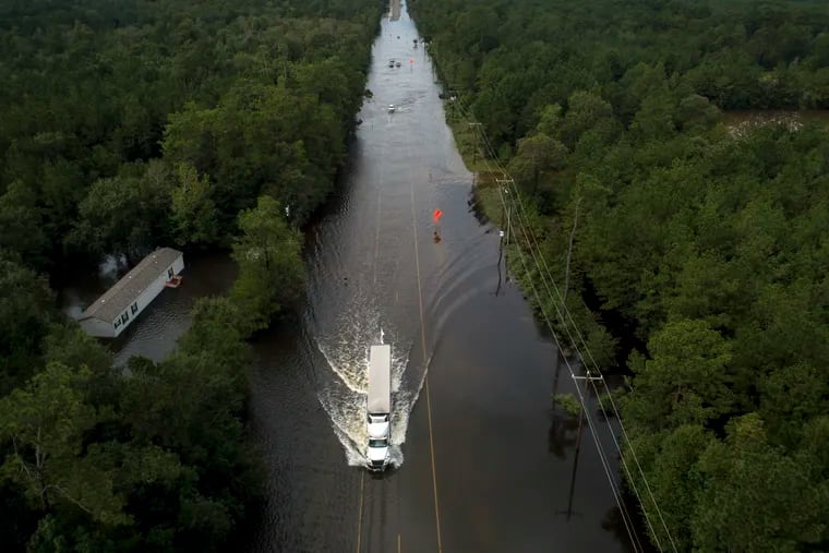 A truck drives through a flooded highway as flooding from the remnants of Tropical Storm Imelda continues in Southeast Texas on Friday, Sept. 20, 2019, in Mauriceville, Texas.
