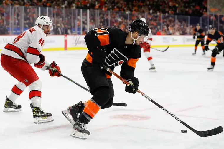 Flyers left wing Scott Laughton skates with the puck against Carolina Hurricanes left wing Jordan Martinook on Friday.