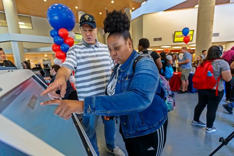 Hanna Archibald, 20, (right) gets help from Matthew McKeon (left) as she tries out the new voting machines at the Community College of Philadelphia in September.