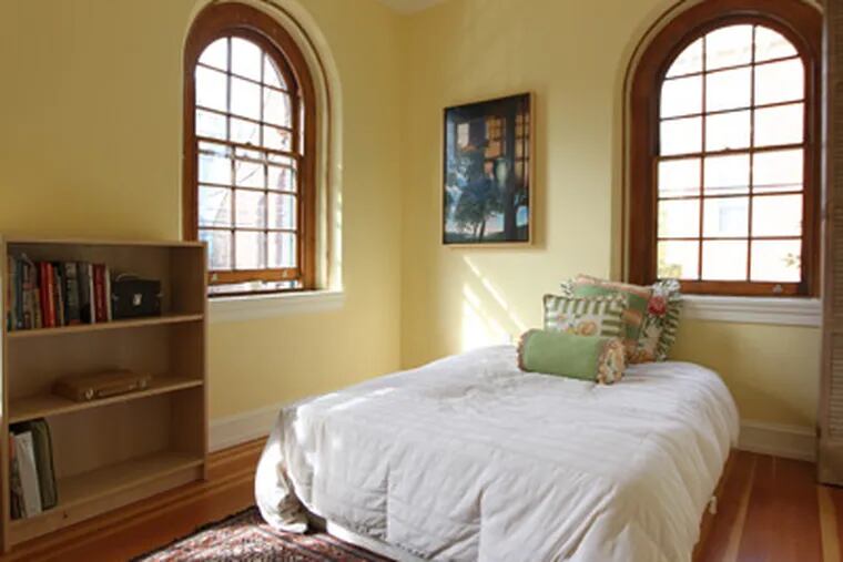 The guest bedroom with the wonderful original windows.House tour: the restored NoLibs carriage house of designers Jeff Carpenter and Sally Ketcham.    ( Michael Bryant / Staff photographer )