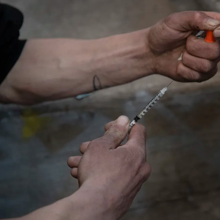 The Centers for Disease Control and Prevention said in a recent letter to a Philadelphia physician that stopping or limiting programs that provide sterile syringes to people with addiction could cause an HIV outbreak. Photo shows a man preparing a syringe to inject drugs near Kensington Ave. in Philadelphia in January 2020.