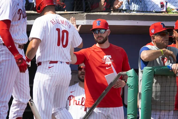 Phillies assistant hitting coach Dustin Lind congratulates J.T. Realmuto after a home run in the first inning on Wednesday in Clearwater, Fla.