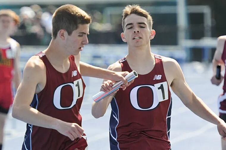 Cardinal Ohara's Jim Belfatto (left) take the baton from Kevin James during the 4x1600 race at the Great Valley Relays. (Ron Tarver/Staff Photographer)