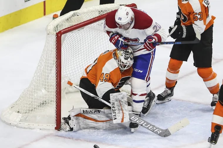 Flyers goalie Alex Lyon stops the puck with the Canadiens' Nicolas Deslauriers bumping him during a Feb. 20 game last season.