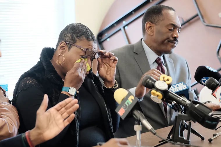 Nicol Newman wipes away tears as she sits next to local NAACP president Minister Rodney Muhammad at the NAACP office.