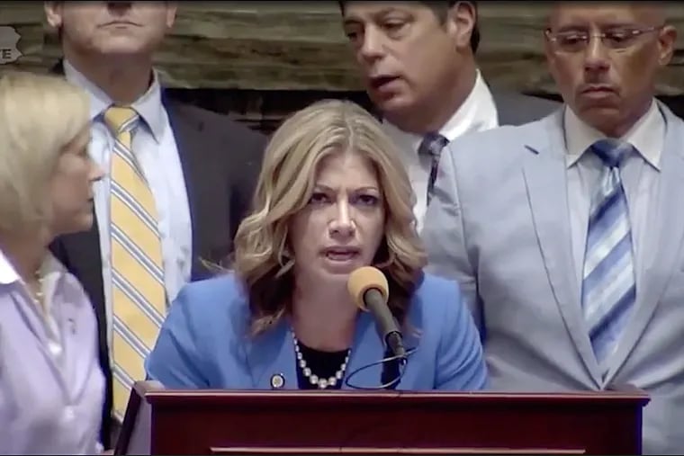Democratic Sen. Katie Muth of Montgomery County reads a letter from a former homeless man while Republican Senate Majority Leader Jake Corman yells in an attempt to get her to stop.