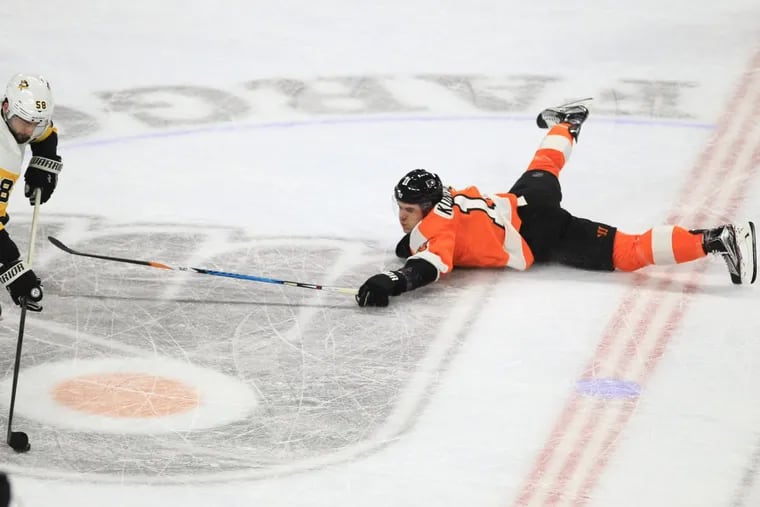 Travis Konecny, right,of the Flyers loses the puck to Kris Letang, left, of the Penguins after falling to the ice during the 1st period at the Wells Fargo Center on Jan. 2, 2018.