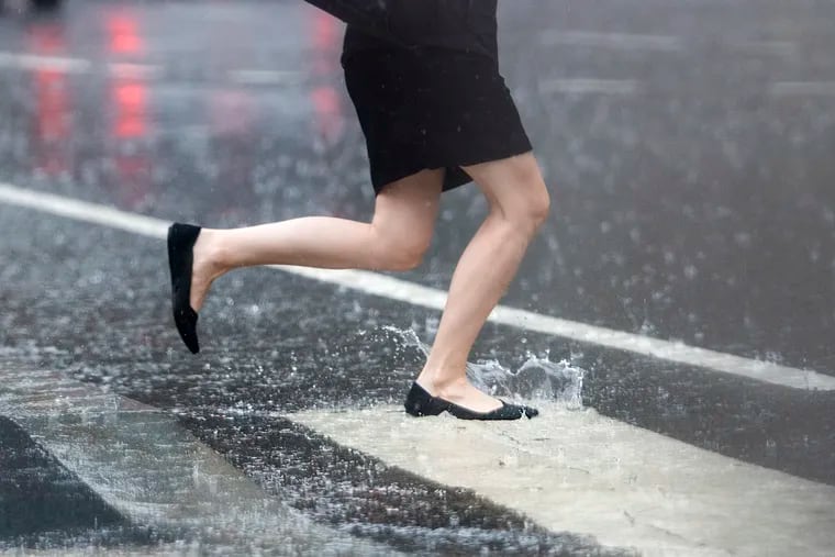A woman runs during heavy rain and thunder storms in Philadelphia on Wednesday.