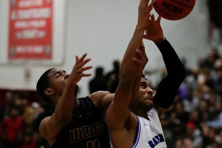 Wildwood Catholic High's Taj Thweatt (right) goes after the basketball against Archbishop Wood High's Jaylen Stinson during the first-quarter in the Dajuan Wagner Play-By-Play Classic at Cherry Hill East High School.