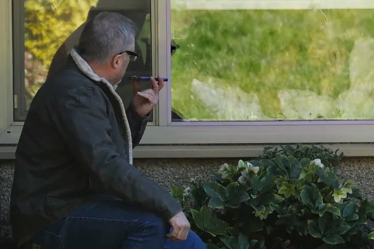 Marty Shape, left, talks to his mother, Judy Shape, right, on the phone as they look at each other through her window, Monday, March 9, 2020, at the Life Care Center in Kirkland, Wash., near Seattle. In-person visits at the facility are not allowed, as the nursing home is at the center of the outbreak of the coronavirus in Washington state.
