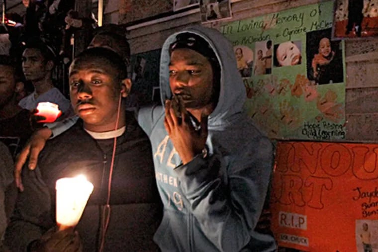 Mourners attend a candlelight vigil in the 5200 block of Chancellor Street in West Philadelphia for two adults and two children killed in a house fire this week. Earlier Tuesday, Mayor Nutter stood at the charred house and urged city residents to make fire safety a top priority. ELIZABETH ROBERTSON / Staff Photographer