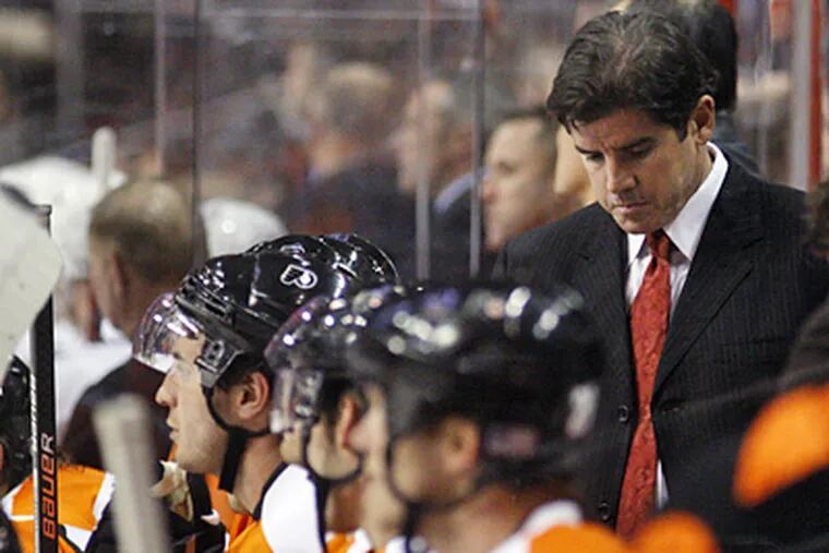 New coach Peter Laviolette, right, looks down in the final seconds of the Flyers' 8-2 loss to the Capitals. (AP Photo/Matt Slocum)