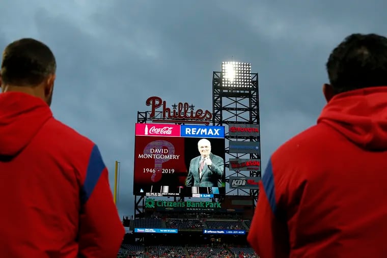 The Phillies remove their caps during a moment of silence for chairman David Montgomery, who passed away last week, before their game against the Brewers on Monday.