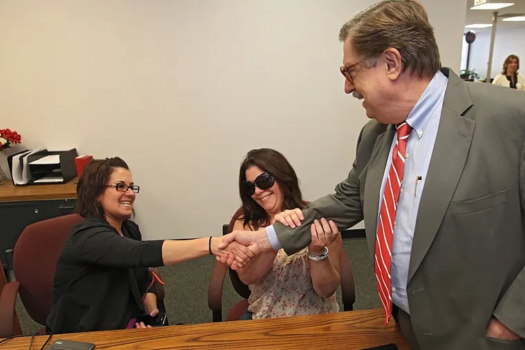 Tamara Davis, left, and Nicola Cucinotta, center, say thank you to D. Bruce Hanes, right, the Recorder of Wills for Montgomery County, for opening up marriage licenses to same-sex couples. (MICHAEL BRYANT / Staff Photographer)