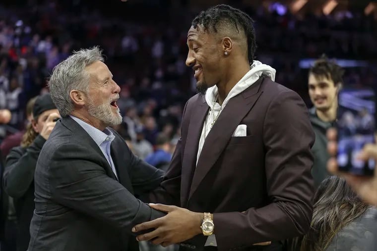 Brett Brown greets Robert Covington after the 76ers' win over the Timberwolves.
